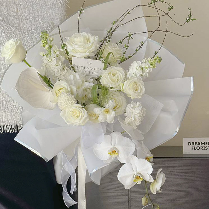 Ejemplo de uso de papel coreano con franjas holográficas. Colores blanco y negro con bordes plateados o dorados. Ideal para envolver flores.