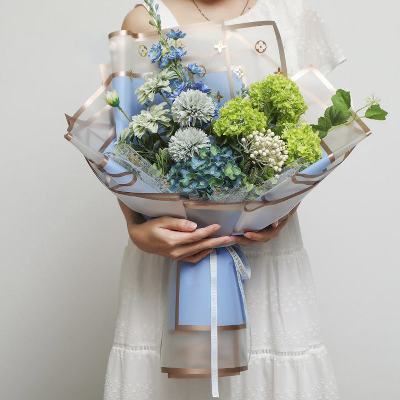 Foto de uso de papel coreano premium con marcos dorados en colores milky tea, rosa, peonia, celeste, durazno, vino y negro. Para ramos y arreglos florales. Material para floristas. Paquete 20 pliegos.