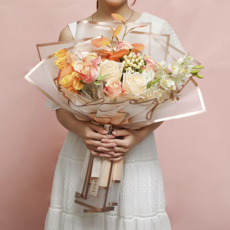 Foto de uso de papel coreano premium con marcos dorados en colores milky tea, rosa, peonia, celeste, durazno, vino y negro. Para ramos y arreglos florales. Material para floristas. PAquete de 20 pliegos.