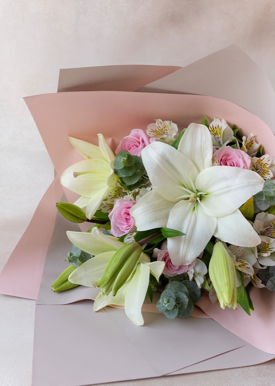 Ejemplo de uso de papel coreano Supreme con listón integrado, listo para usar. Colores beige, amarillo, rosa, lila y celeste para envolver ramos de flores. Materiales para florerías.